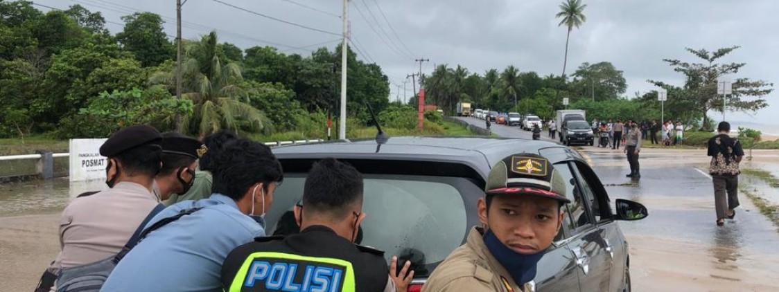 Personel Polres Bateng Bantu Pengendara Melewati Genangan Air Laut