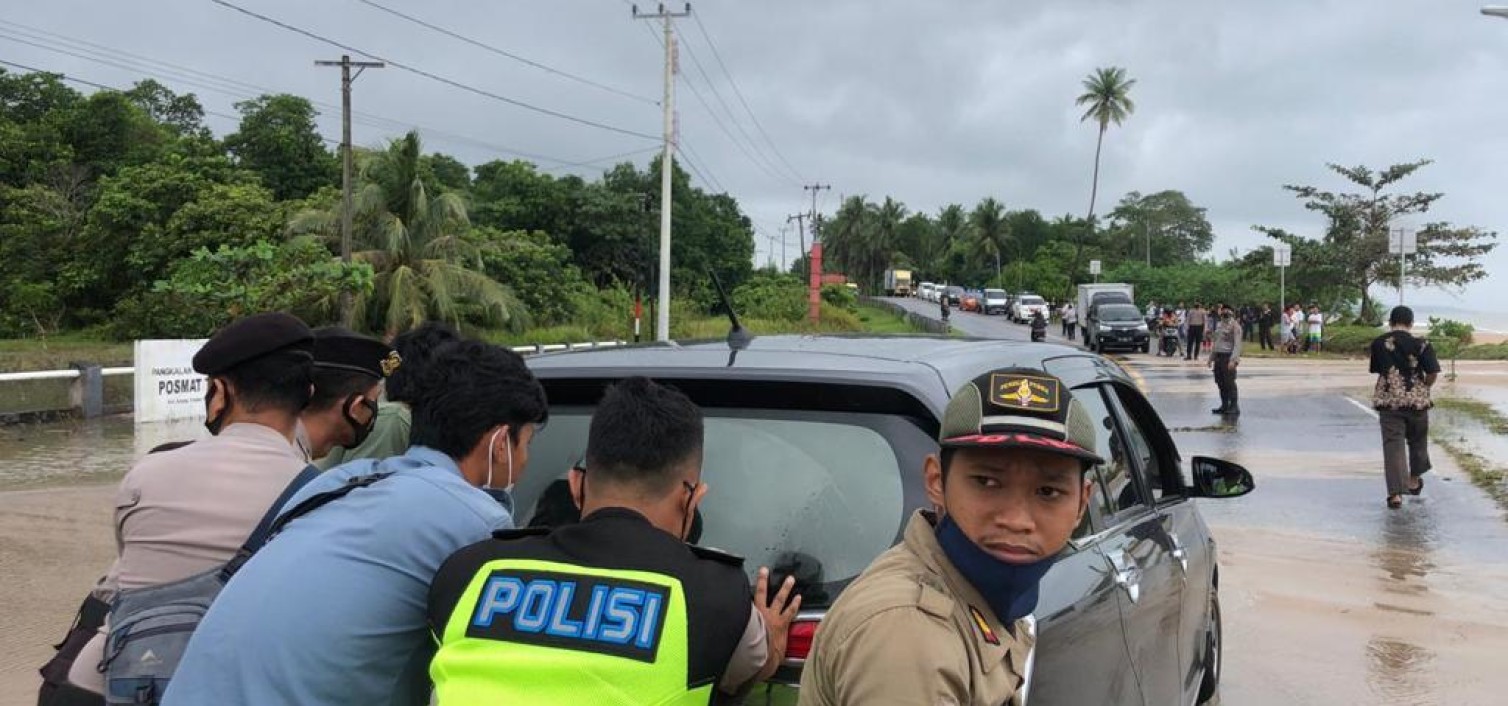 Personel Polres Bateng Bantu Pengendara Melewati Genangan Air Laut