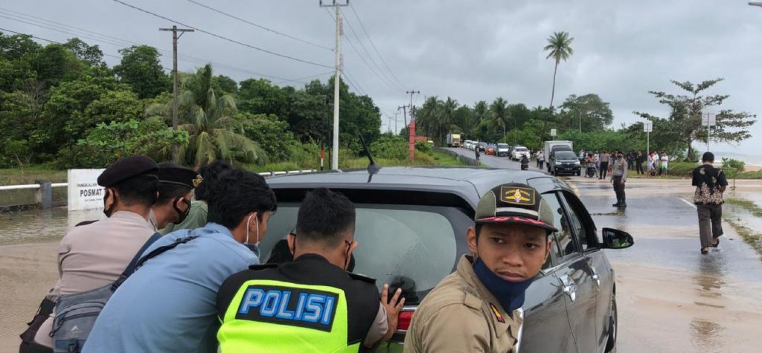 Personel Polres Bateng Bantu Pengendara Melewati Genangan Air Laut