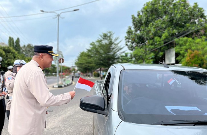 POLRES BANGKA TENGAH BAGI-BAGI BENDERA DAN PASANG STIKER MERAH PUTIH DI BUNDARAN IKAN KOBA
